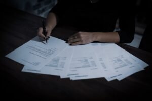 Firma del contrato de compraventa de un coche sobre una mesa: el documento con el que arrancan los plazos del cambio de nombre