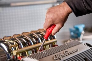 Meccanico al lavoro sul motore di un'auto durante la manutenzione