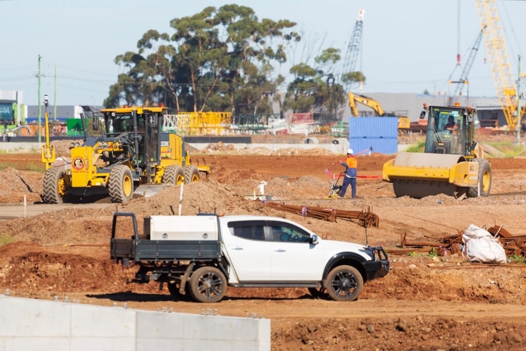 A white dual-cab work ute with a tray and toolbox parked on an Australian construction site — the kind of vehicle an ATO logbook is kept for