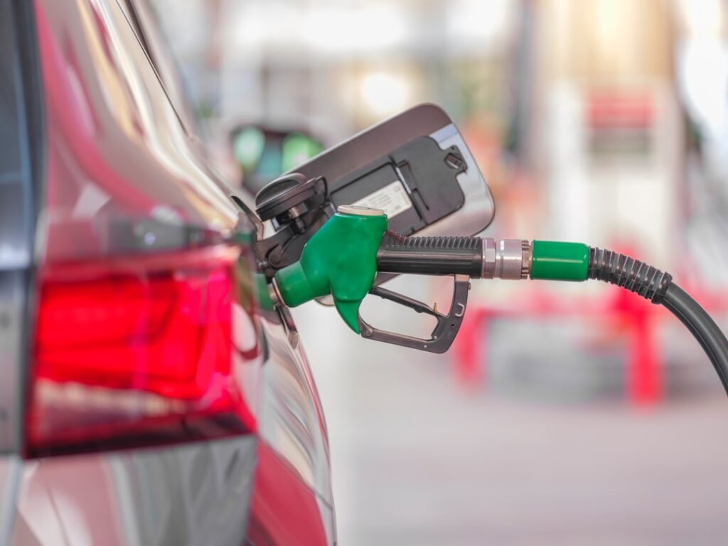 Refuelling a car at a gas station: real gas mileage is measured at the pump, not on the window sticker
