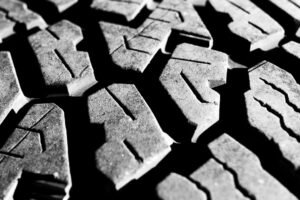 Close-up of a car tire tread — the grooves whose depth decides how long tires last