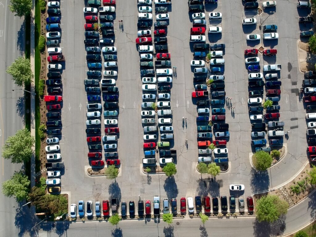 Aerial view of a parking lot full of cars — leasing and buying differ most in what the contract is required to disclose