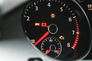 Spia motore gialla accesa sul quadro strumenti di un'auto, insieme ad altre spie di avaria