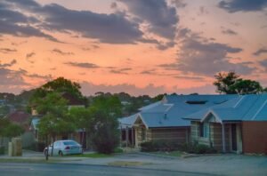 A car parked outside a suburban house in Perth at first light, before the drive that decides whether the day's kilometres are work-related